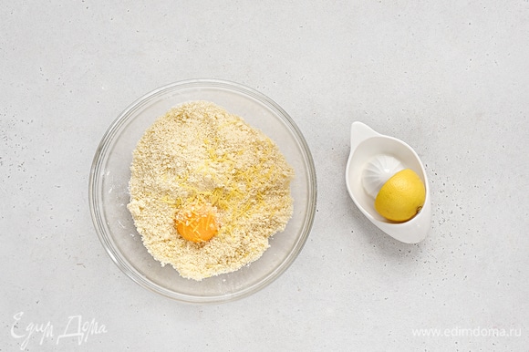 Добавьте желток, сок и цедру лимона, еще раз хорошо перемешайте, пока тесто не соберется в шар.