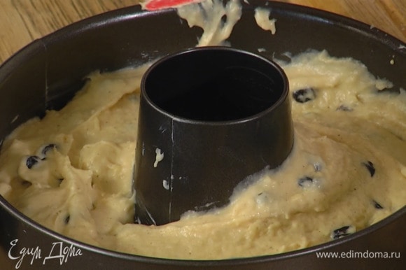 Круглую разъемную форму для выпечки с отверстием посередине смазать оставшимся сливочным маслом и равномерно выложить тесто.