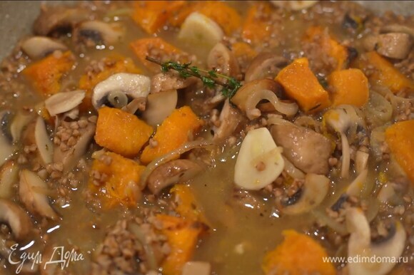 Запеченную тыкву, удалив тимьян, выложить к грибам и перемешать, добавить гречку, все посолить, залить горячим бульоном и, помешивая, дать жидкости выпариться.