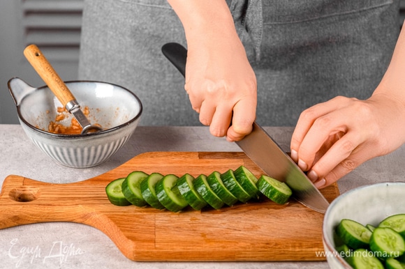 Отбейте огурцы молотком для мяса и нарежьте их кружочками. Переложите их в отдельную миску и залейте маринадом. Оставьте минимум на 20 минут.
