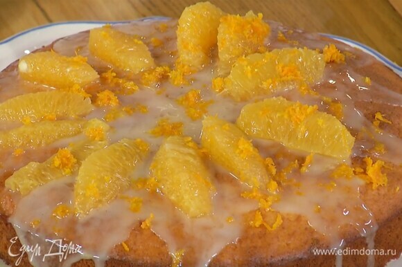 Готовый пирог полить глазурью, сверху разложить мякоть апельсина и посыпать цедрой.